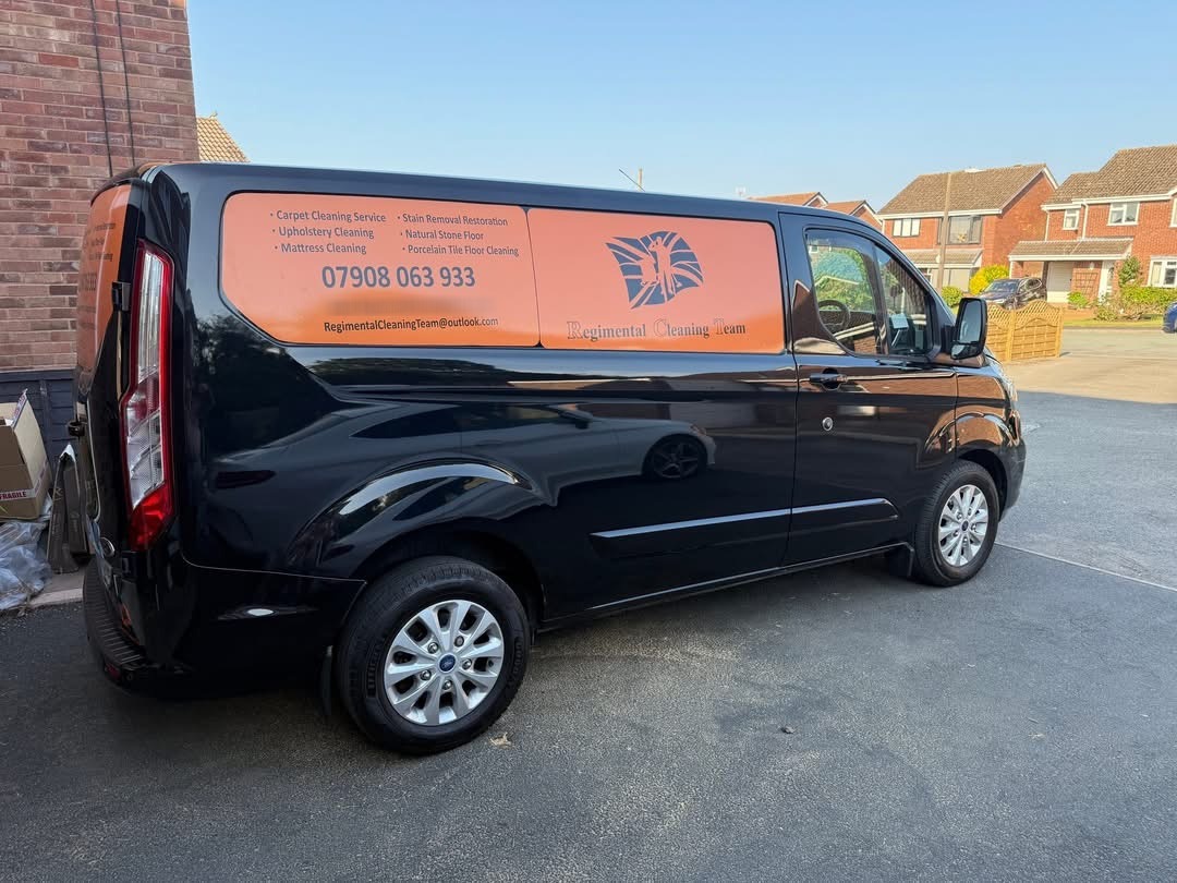 Black Regimental Cleaning Team van with orange livery listing carpet, upholstery, mattress and stone floor cleaning