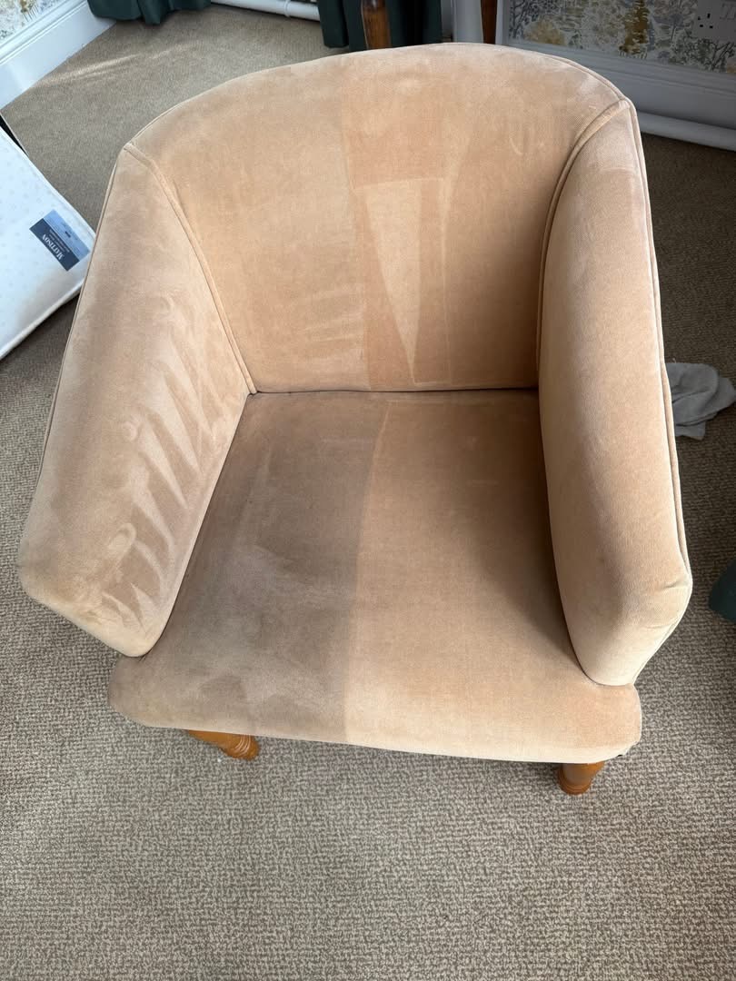 Beige tub chair half cleaned, showing a clear line between dirty and clean fabric